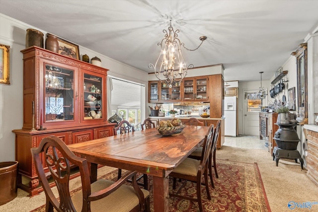 dining area with a chandelier and light colored carpet