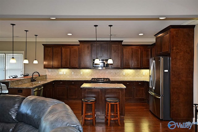 kitchen featuring hanging light fixtures, a breakfast bar area, light stone counters, kitchen peninsula, and stainless steel appliances