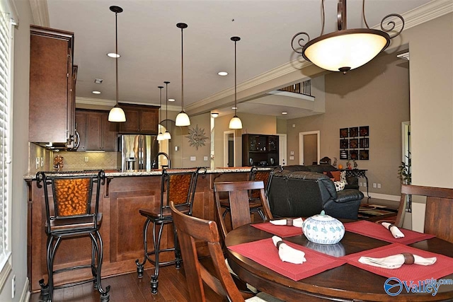 dining space with ornamental molding and dark wood-type flooring