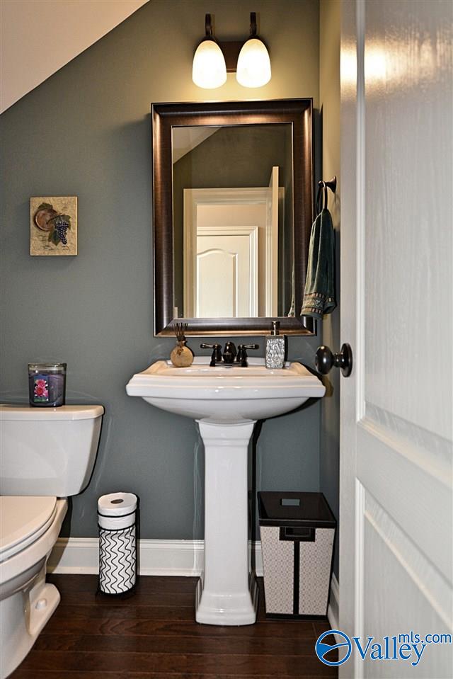 bathroom with sink, hardwood / wood-style floors, vaulted ceiling, and toilet