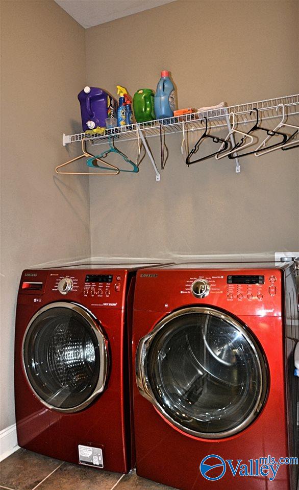 laundry room with washing machine and dryer and dark tile patterned flooring