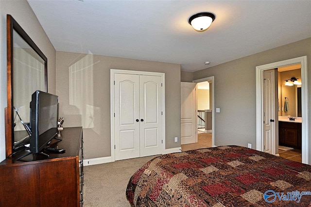 bedroom with light carpet, a closet, and ensuite bathroom