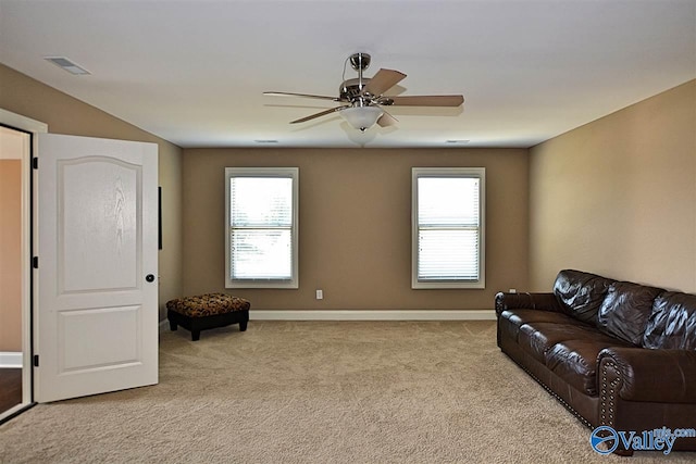 living area with light carpet and ceiling fan