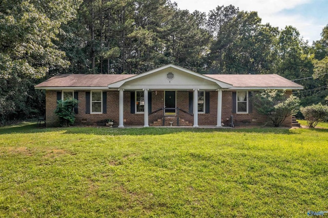 ranch-style house featuring covered porch and a front lawn