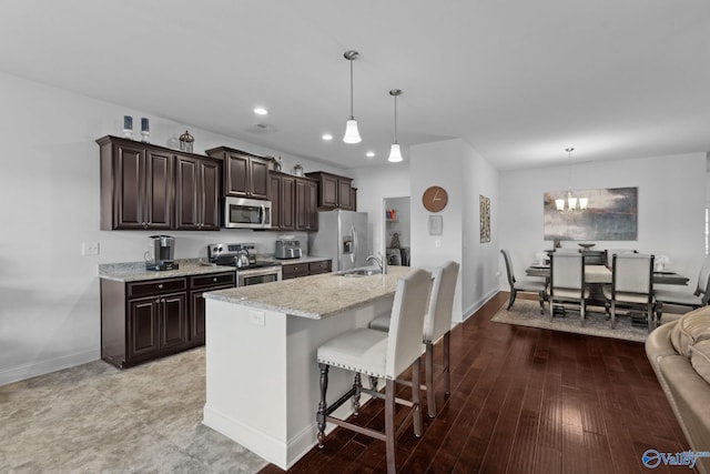 kitchen featuring appliances with stainless steel finishes, decorative light fixtures, hardwood / wood-style flooring, and a notable chandelier