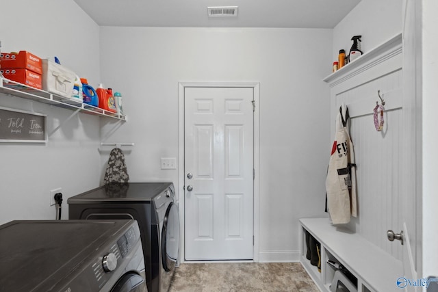 laundry area with separate washer and dryer and light carpet