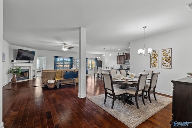 dining room featuring dark wood-type flooring and ceiling fan with notable chandelier