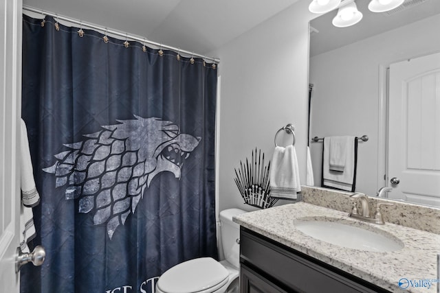 bathroom with vanity, toilet, and vaulted ceiling