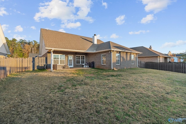 back of house with a lawn and a patio