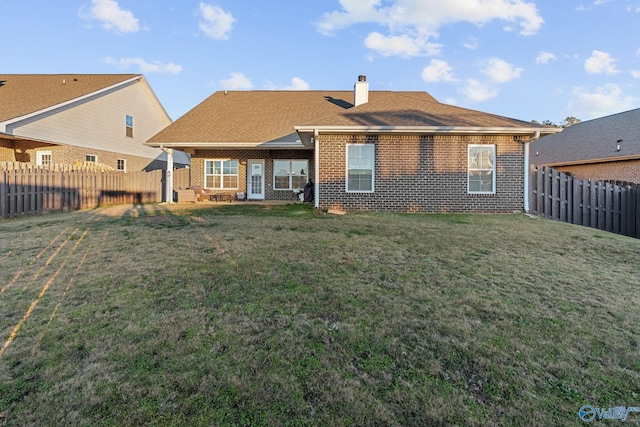 rear view of property with a yard