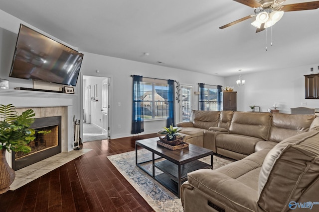 living room featuring a fireplace, ceiling fan with notable chandelier, and hardwood / wood-style flooring