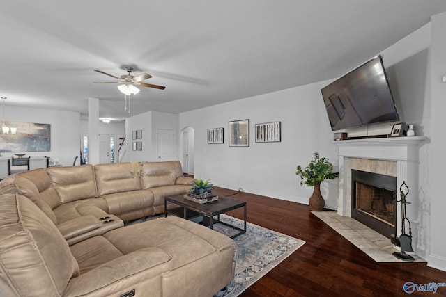 living room with light hardwood / wood-style floors, ceiling fan, and a tiled fireplace