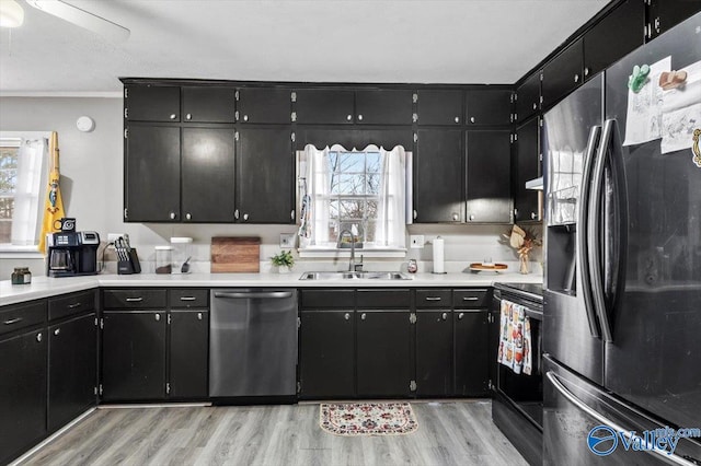 kitchen with sink, stainless steel appliances, and light hardwood / wood-style flooring