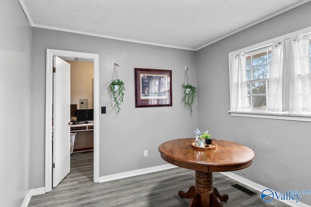 dining space with hardwood / wood-style floors and ornamental molding