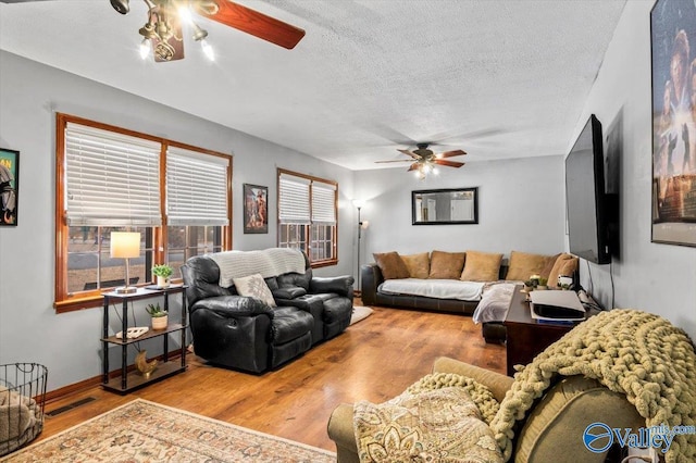 living room featuring a textured ceiling, light hardwood / wood-style floors, and ceiling fan