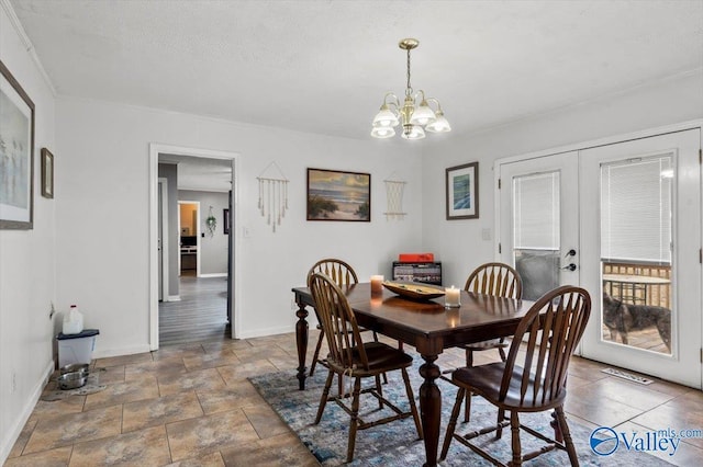 dining area with french doors, a textured ceiling, and a notable chandelier