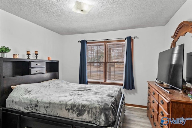 bedroom featuring light wood-type flooring and a textured ceiling