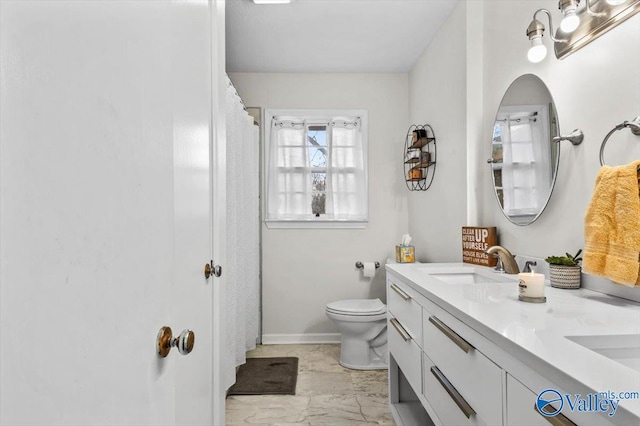 bathroom with vanity, toilet, and a wealth of natural light