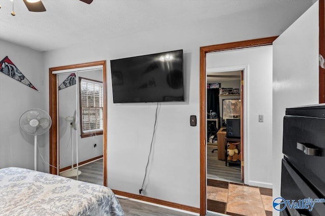 bedroom with ceiling fan, a closet, and a textured ceiling