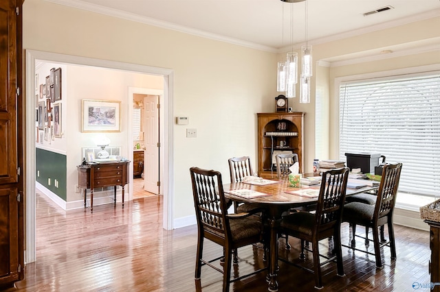 dining space featuring crown molding and hardwood / wood-style floors