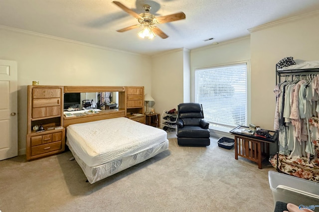 bedroom featuring ceiling fan, ornamental molding, light carpet, and a textured ceiling