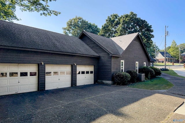 view of side of property with central AC unit and a garage