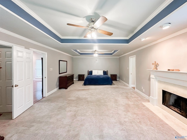 bedroom with a tray ceiling, crown molding, and carpet flooring