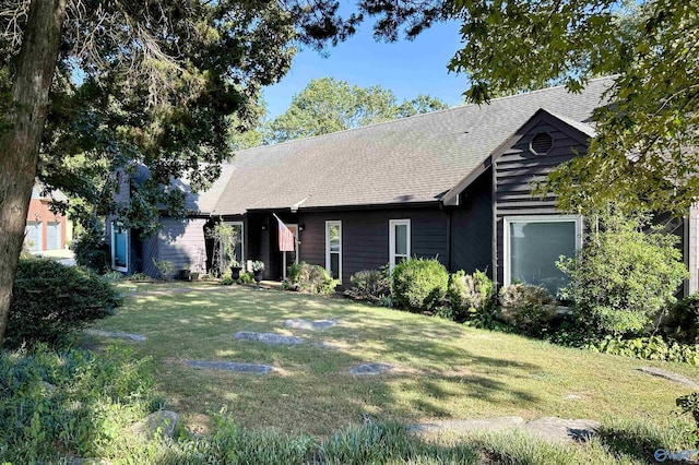 ranch-style house with roof with shingles and a front yard