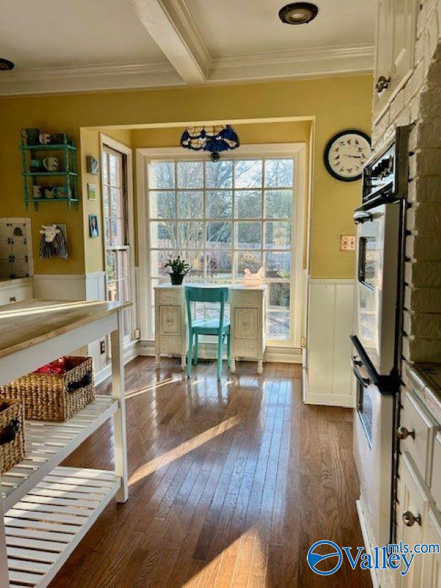 interior space featuring a chandelier, beam ceiling, dark hardwood / wood-style floors, and crown molding