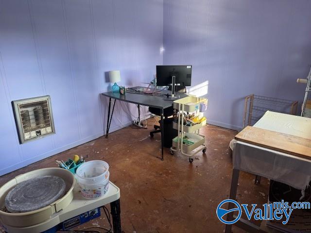 home office with heating unit and concrete flooring