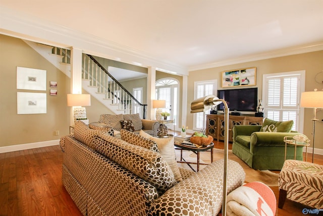 living area featuring stairway, a healthy amount of sunlight, crown molding, and wood finished floors