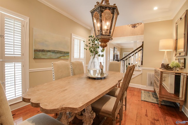 dining space with stairs, visible vents, light wood-style floors, and crown molding