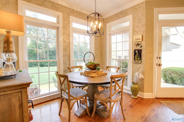 dining room with baseboards, light wood finished floors, wallpapered walls, crown molding, and a wealth of natural light