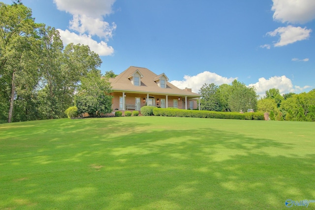 view of front of home featuring brick siding, covered porch, and a front yard