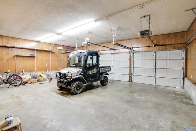 garage featuring a garage door opener and wood walls