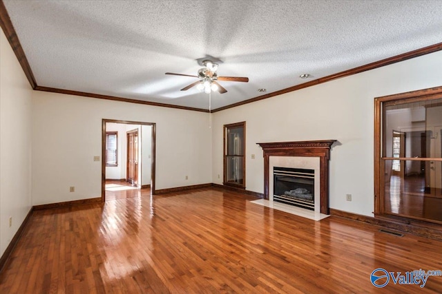 unfurnished living room featuring wood-type flooring, a textured ceiling, ceiling fan, and crown molding