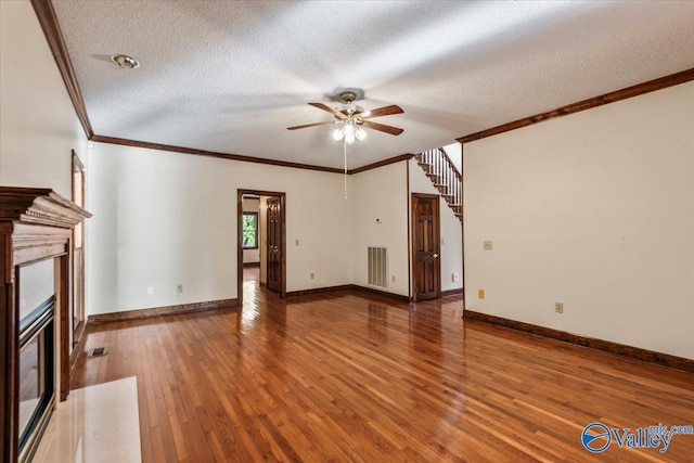 unfurnished living room featuring hardwood / wood-style flooring, ceiling fan, crown molding, and a textured ceiling