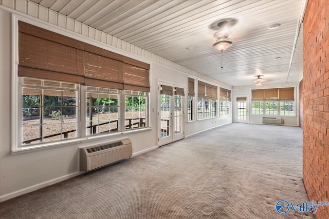 unfurnished sunroom featuring ceiling fan, wood ceiling, and a wall unit AC