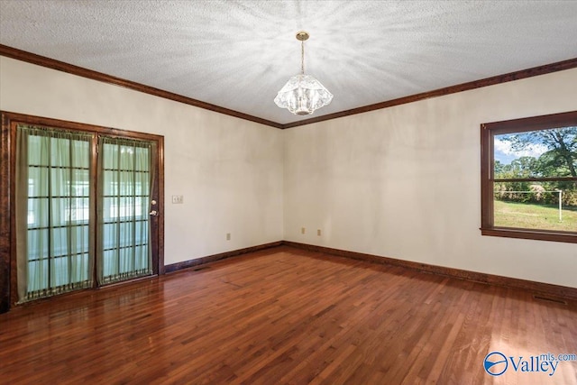 empty room with crown molding, wood-type flooring, a textured ceiling, and an inviting chandelier