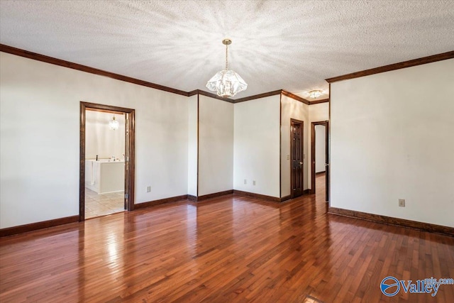 empty room featuring hardwood / wood-style floors, a textured ceiling, and a notable chandelier