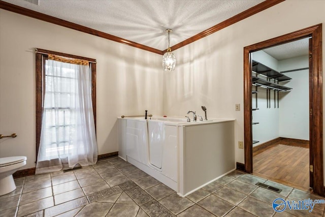 bathroom featuring wood-type flooring, a textured ceiling, toilet, and crown molding