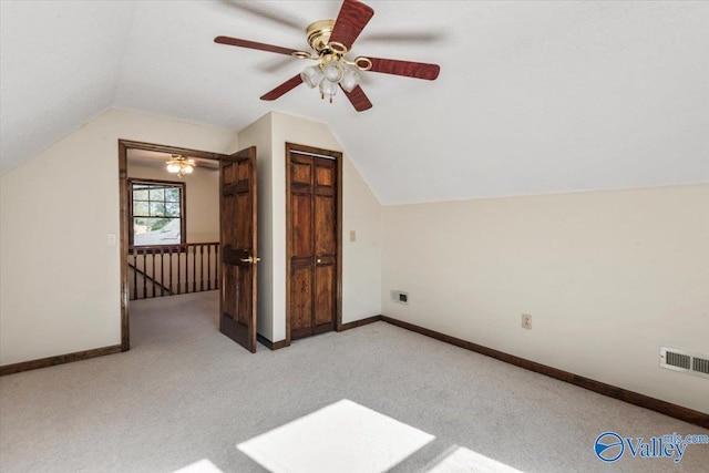 additional living space with ceiling fan, light colored carpet, and lofted ceiling