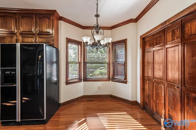 kitchen featuring pendant lighting, black refrigerator with ice dispenser, an inviting chandelier, a textured ceiling, and wood-type flooring