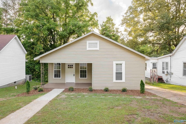 view of front of home with a porch, a front yard, central AC unit, and cooling unit
