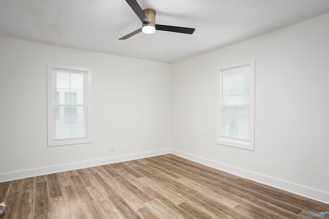 unfurnished room featuring wood finished floors, a ceiling fan, and baseboards