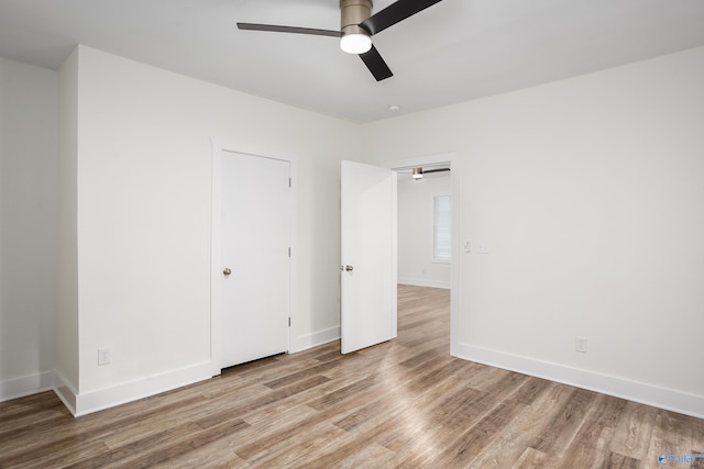 unfurnished bedroom featuring wood finished floors, baseboards, and a ceiling fan