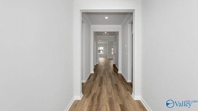 hallway with hardwood / wood-style flooring and ornamental molding