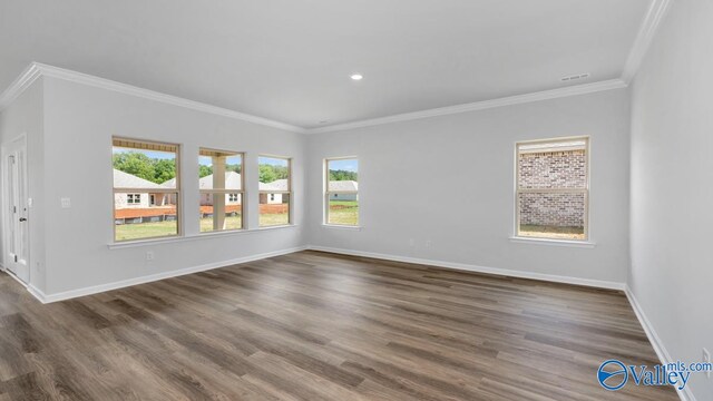 empty room featuring ornamental molding and dark wood-type flooring