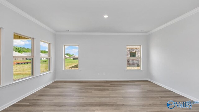 empty room with ornamental molding and light wood-type flooring