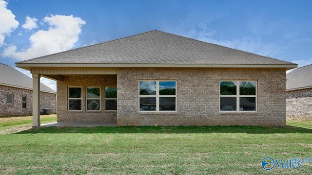 back of house featuring a patio area and a lawn